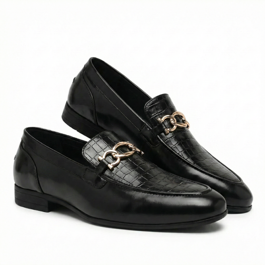 Black leather loafers with gold chain detail on a white background