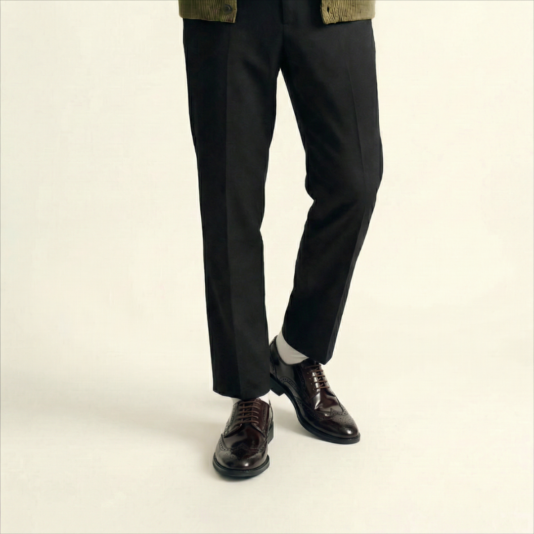 A dark brown leather wingtip oxford shoe with decorative brogue perforations