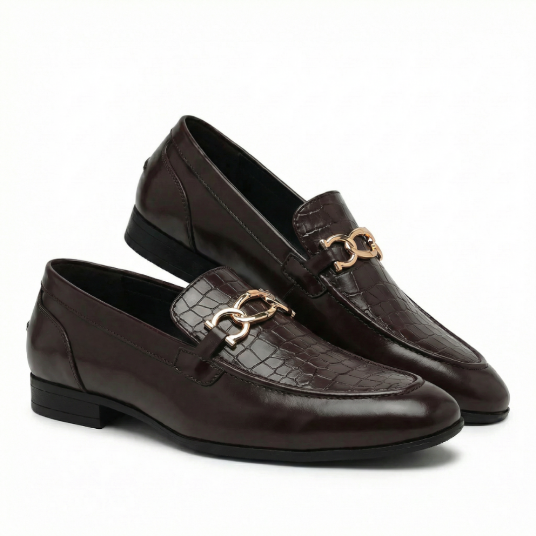 A pair of dark brown leather loafers with a crocodile-embossed pattern and a polished gold-tone displayed on a clean white background.