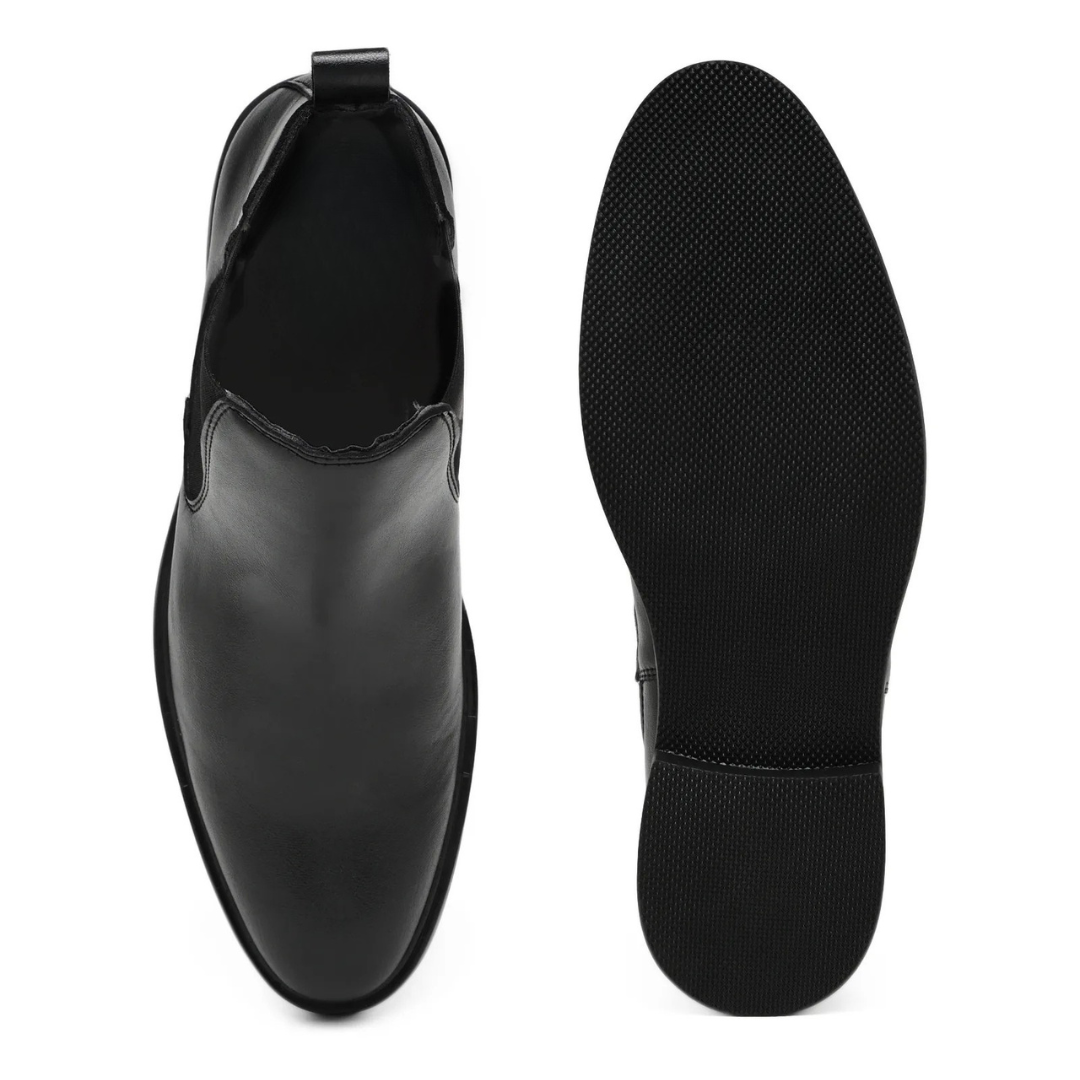 A pair of black leather Chelsea-style ankle boots shown from the top and side, with the outsole visible on a plain white background.