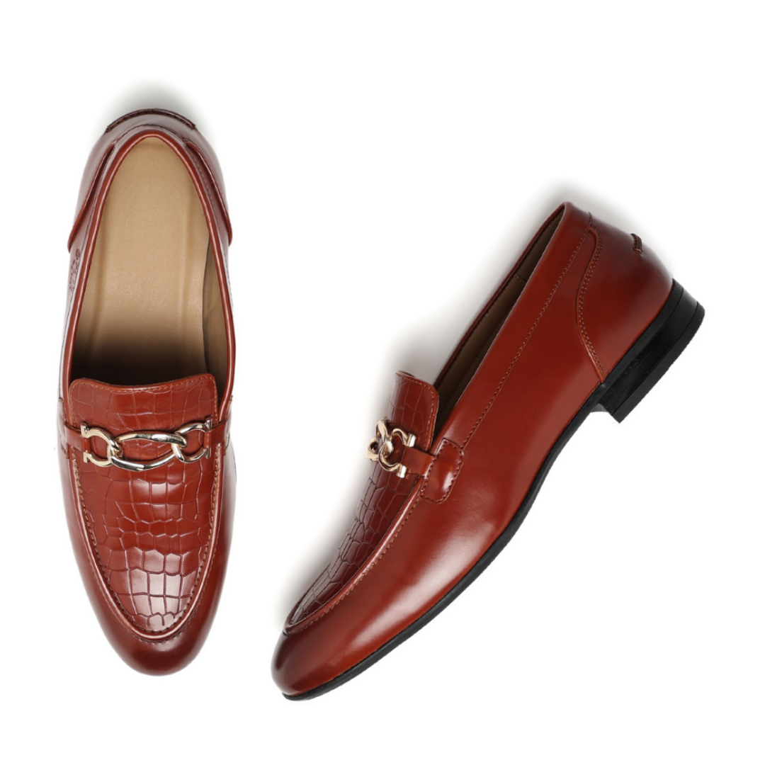 A pair of women's brown leather loafers, one shown from a top-down view and the other from a side angle. The shoes feature a glossy finish, a decorative chain strap with a gold-tone metal link, and a black sole.