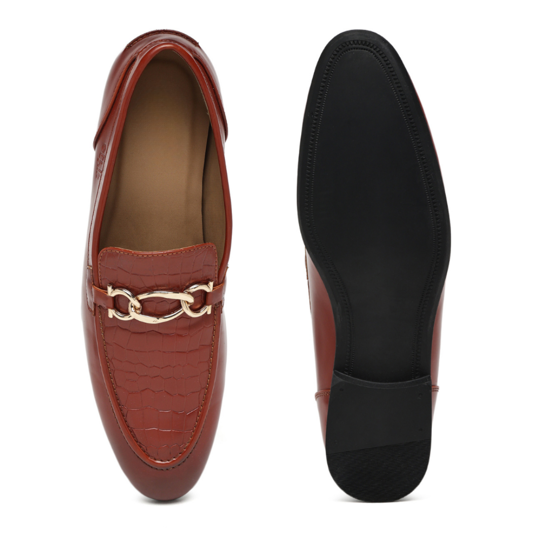 A pair of men's loafers shown from the top and side, featuring a reddish-brown leather upper with a crocodile-embossed pattern, a gold-tone chain detail across the vamp, and a black outsole.